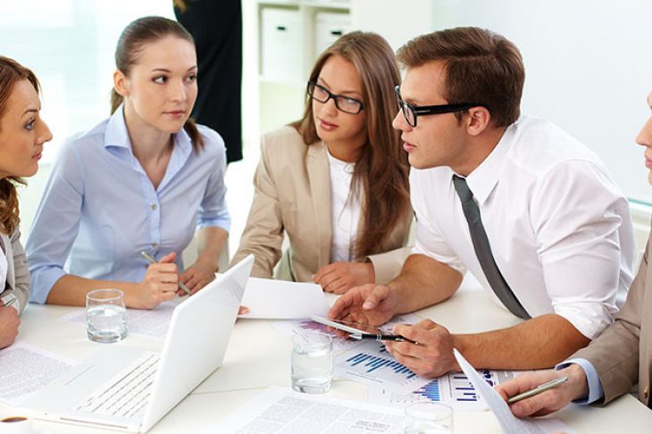 Image of confident partners looking at their colleague at meeting